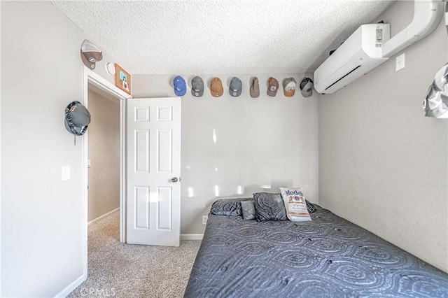 carpeted bedroom with baseboards, a textured ceiling, and a wall unit AC