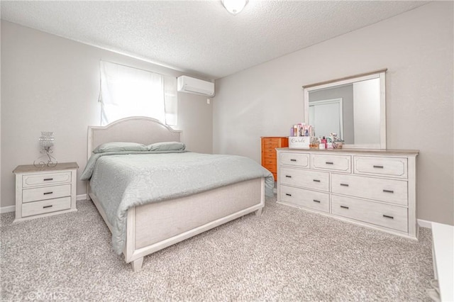 bedroom featuring carpet flooring, baseboards, a wall mounted air conditioner, and a textured ceiling