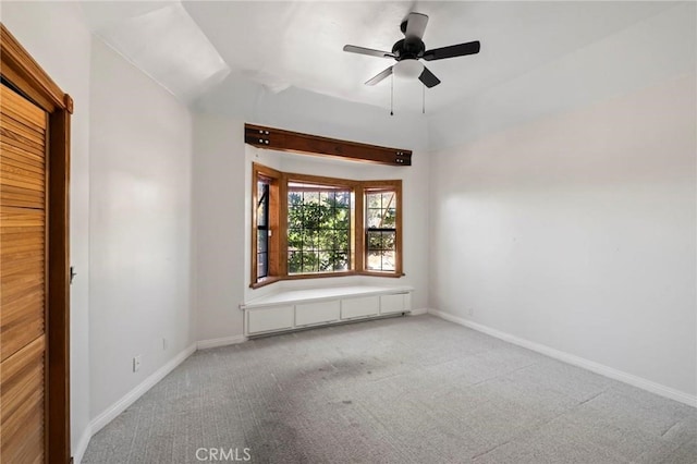 spare room featuring baseboards, carpet floors, and ceiling fan