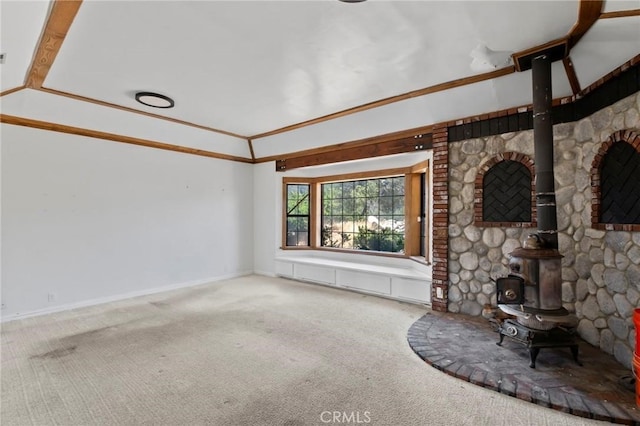 unfurnished living room featuring crown molding, a wood stove, and carpet floors