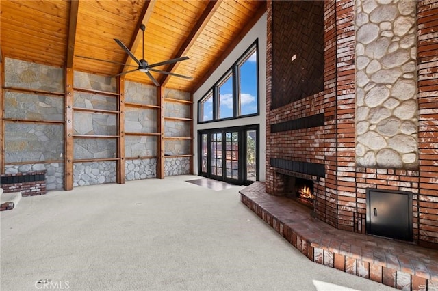 unfurnished living room featuring a ceiling fan, carpet, beam ceiling, wooden ceiling, and a brick fireplace