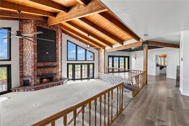 unfurnished living room featuring beamed ceiling, a fireplace, visible vents, and ceiling fan