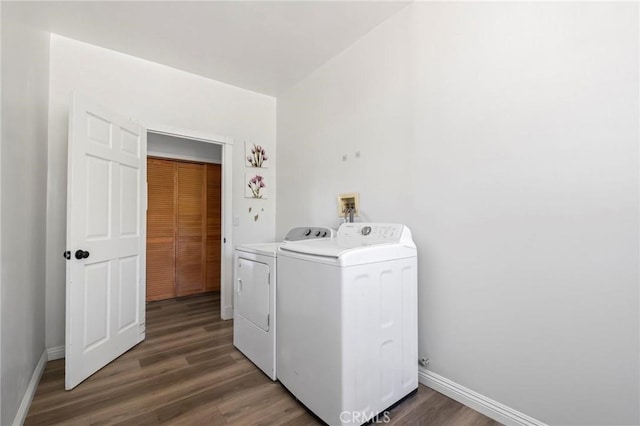 laundry area featuring laundry area, washing machine and dryer, baseboards, and wood finished floors