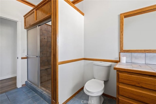 full bath with tile patterned flooring, toilet, baseboards, and a stall shower