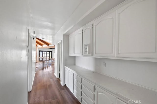 hall with lofted ceiling with beams, baseboards, and dark wood-style flooring