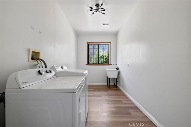 laundry room with visible vents, baseboards, laundry area, wood finished floors, and independent washer and dryer