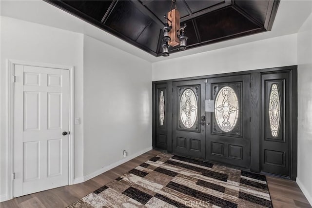 entrance foyer featuring coffered ceiling, baseboards, and wood finished floors