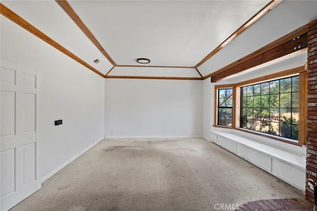 carpeted empty room with baseboards, lofted ceiling, and ornamental molding