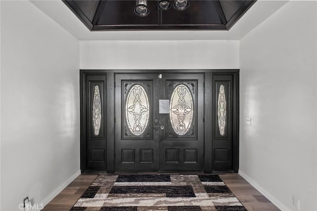 entryway featuring dark wood-type flooring and baseboards