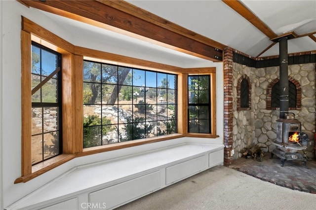 room details featuring beam ceiling, carpet, and a wood stove