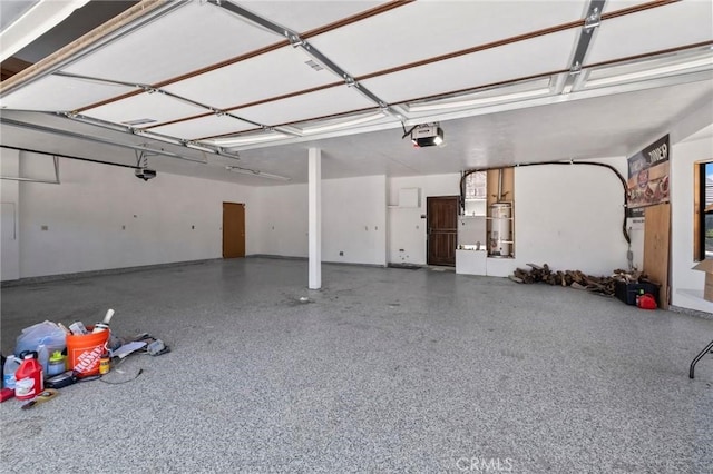 garage featuring strapped water heater and a garage door opener