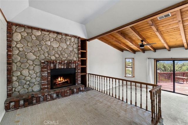 unfurnished living room with carpet floors, lofted ceiling with beams, a fireplace, ceiling fan, and wooden ceiling