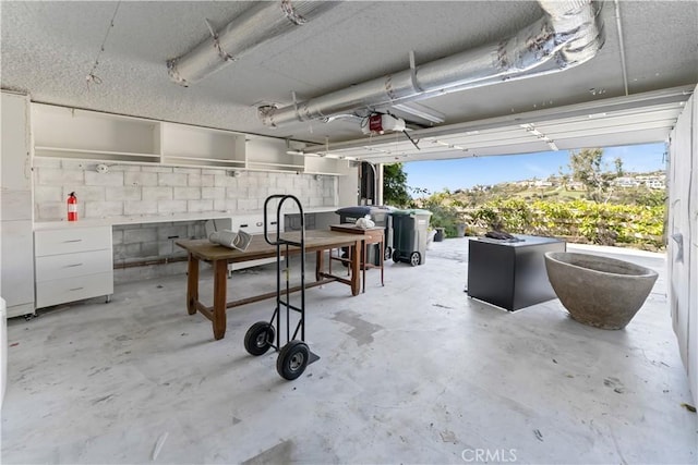 garage with a garage door opener and concrete block wall