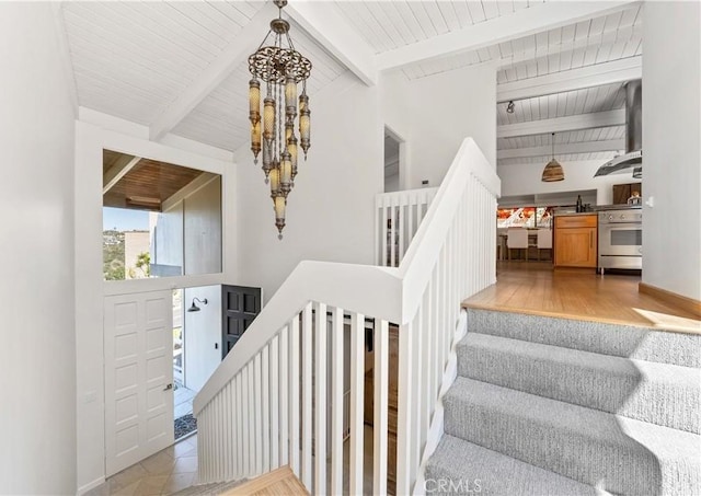 staircase featuring wood finished floors, baseboards, an inviting chandelier, wood ceiling, and beamed ceiling