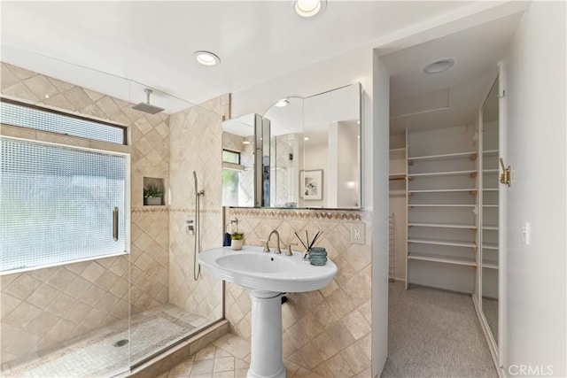 full bath with recessed lighting, a shower stall, a spacious closet, tile walls, and tasteful backsplash