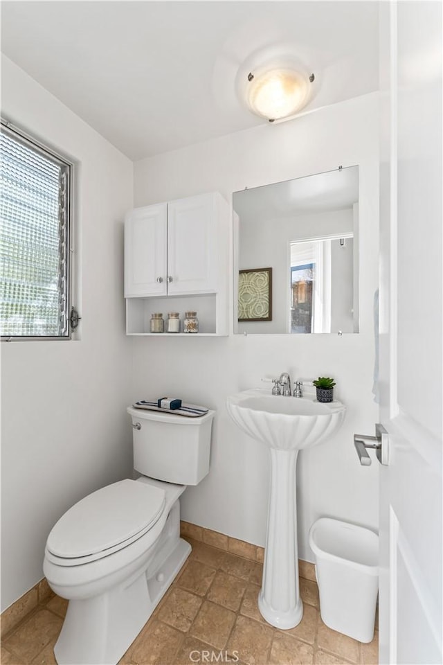 half bath with toilet and baseboards