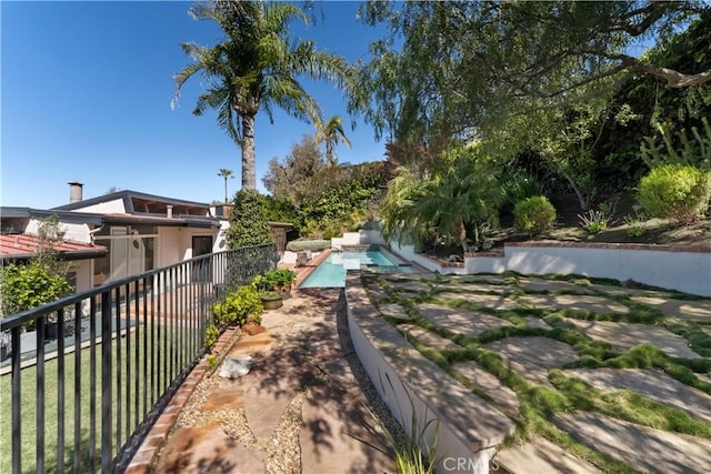 view of yard with a patio area, a fenced in pool, and fence