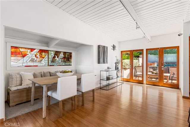 dining space with beam ceiling and wood finished floors