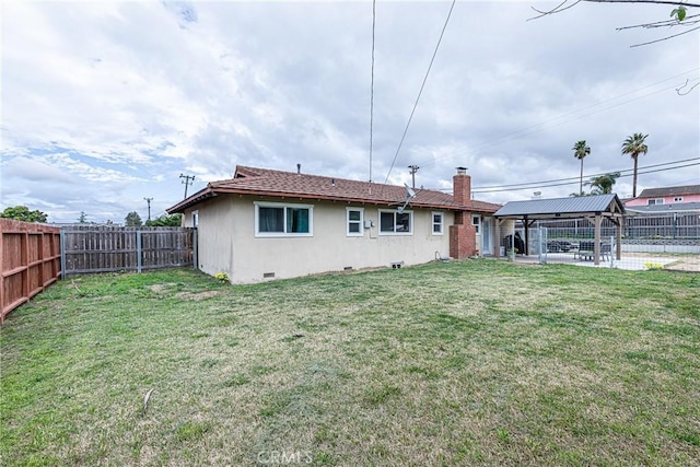 back of house featuring a yard, a fenced backyard, a chimney, a gazebo, and crawl space