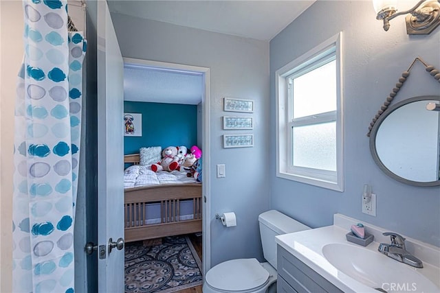 ensuite bathroom featuring toilet, curtained shower, ensuite bath, and vanity