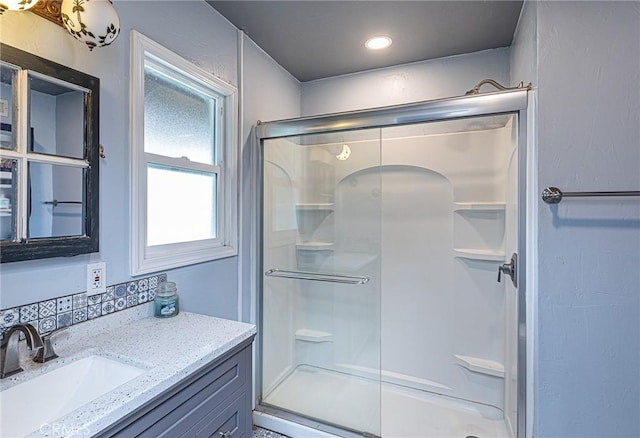 bathroom with recessed lighting, vanity, and a shower stall