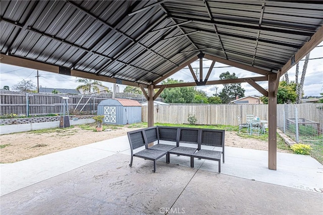 view of patio / terrace featuring an outbuilding, a shed, an outdoor hangout area, and a fenced backyard