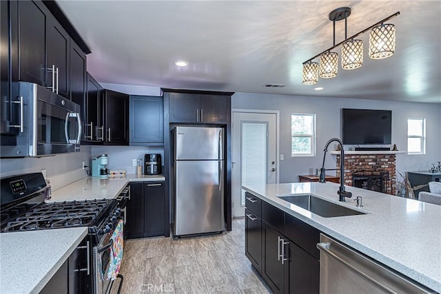 kitchen featuring a sink, stainless steel appliances, a healthy amount of sunlight, and open floor plan