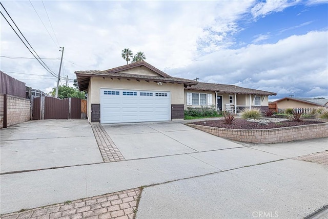 ranch-style home with fence, concrete driveway, stucco siding, a garage, and a gate