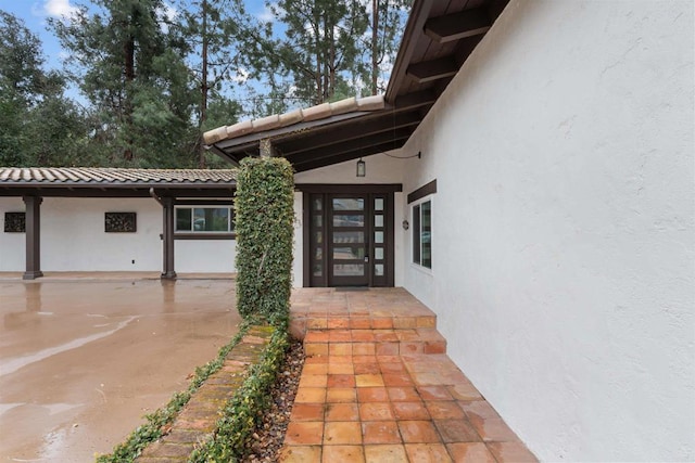 entrance to property featuring stucco siding and a tiled roof