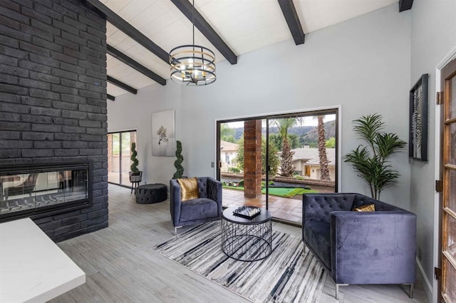 32404 Womsi Rd, Pauma Valley, CA 92061 - living area featuring beam ceiling, a chandelier, a brick fireplace, high vaulted ceiling, and wood finished floors