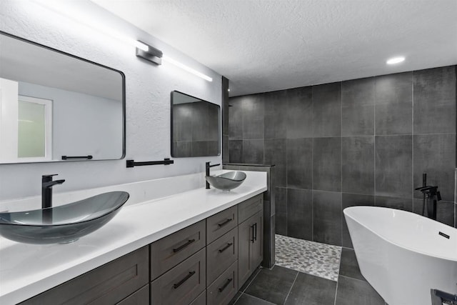 32404 Womsi Rd, Pauma Valley, CA 92061 - bathroom with double vanity, a soaking tub, a textured ceiling, tile walls, and tile patterned flooring