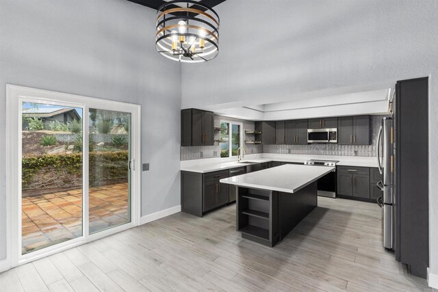 32404 Womsi Rd, Pauma Valley, CA 92061 - kitchen with open shelves, appliances with stainless steel finishes, a center island, light countertops, and a high ceiling