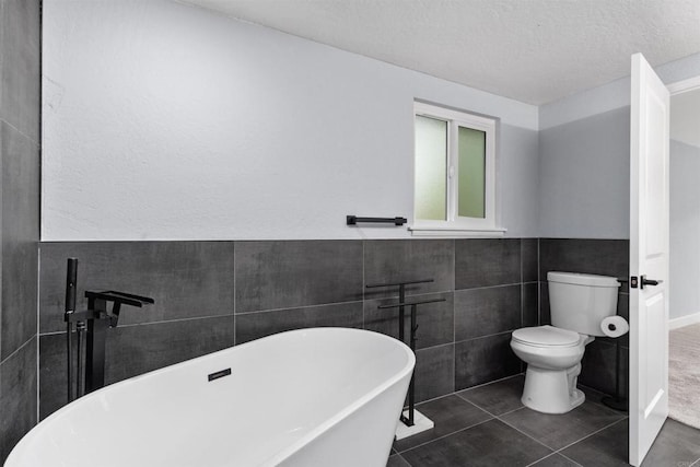 32404 Womsi Rd, Pauma Valley, CA 92061 - bathroom featuring a soaking tub, tile walls, tile patterned flooring, a wainscoted wall, and a textured ceiling