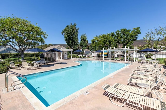 pool with a patio area and fence