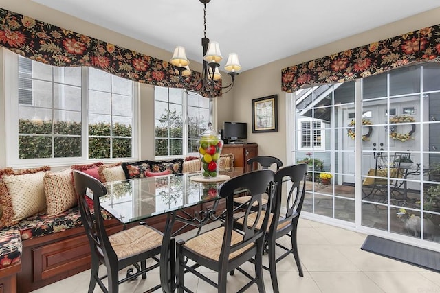 dining area with light tile patterned floors and a chandelier