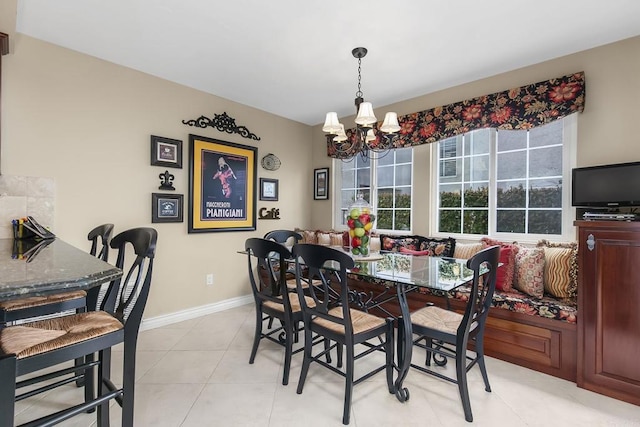 dining area featuring a notable chandelier, light tile patterned flooring, and baseboards