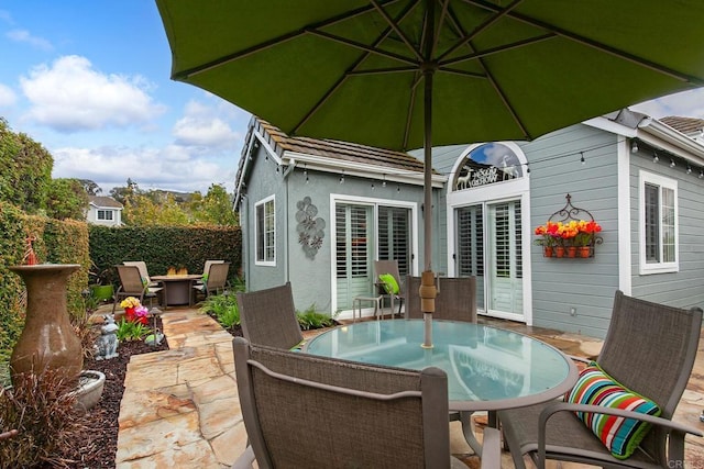 view of patio featuring outdoor dining area, a fire pit, and fence