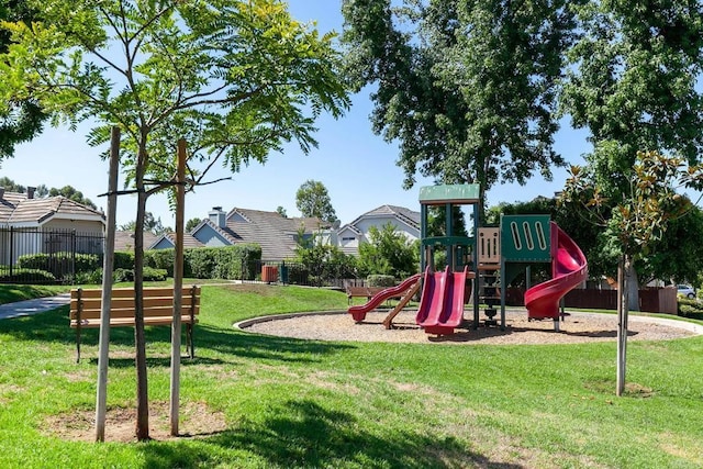 community playground featuring a yard and fence