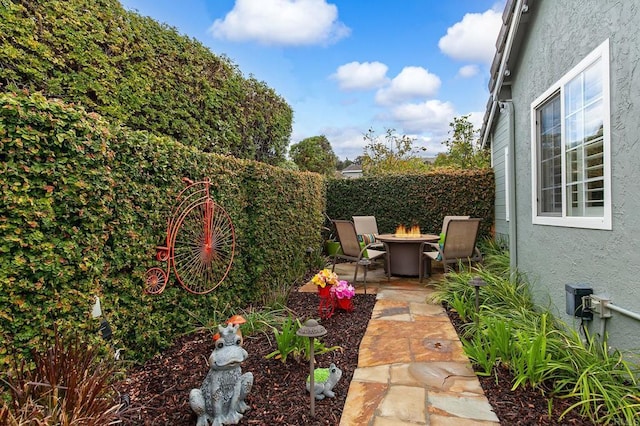 view of yard featuring an outdoor fire pit, a patio, and fence