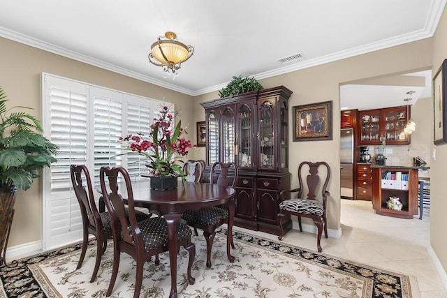 dining room featuring light tile patterned floors, visible vents, and ornamental molding