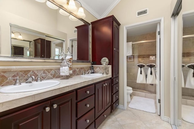 bathroom with crown molding, visible vents, a shower stall, and a sink