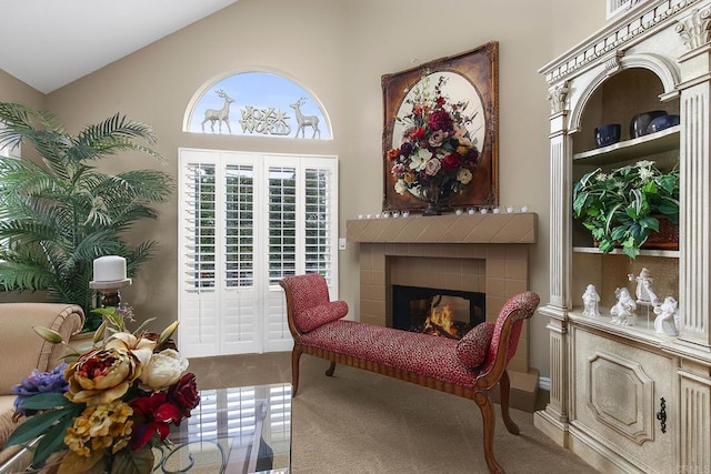 living area featuring a tiled fireplace and high vaulted ceiling