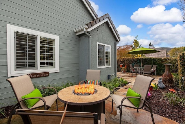 view of patio featuring outdoor dining area and an outdoor fire pit