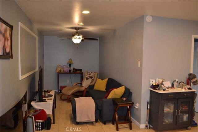 living area with light tile patterned flooring and a ceiling fan