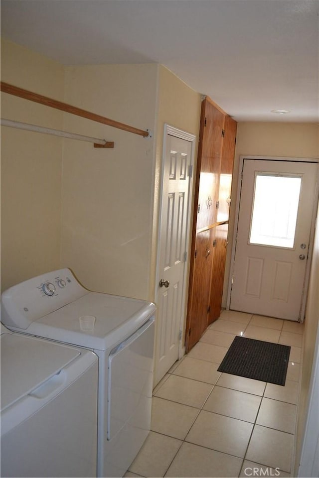 clothes washing area with light tile patterned floors, laundry area, and separate washer and dryer