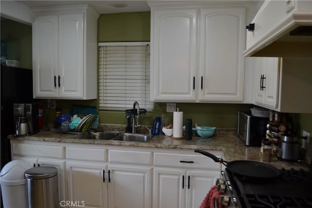 kitchen featuring stainless steel electric range oven, light stone countertops, a sink, white cabinets, and under cabinet range hood