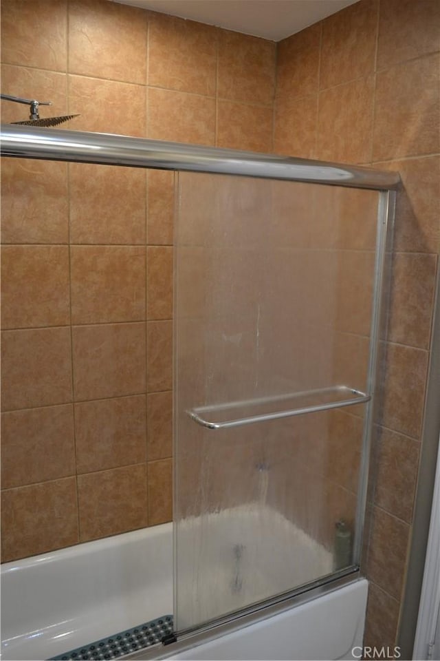 bathroom with shower / bath combination with glass door