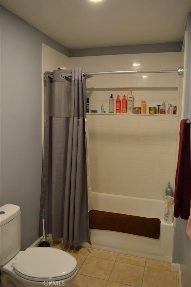 bathroom with tile patterned floors, toilet, and shower / tub combo with curtain