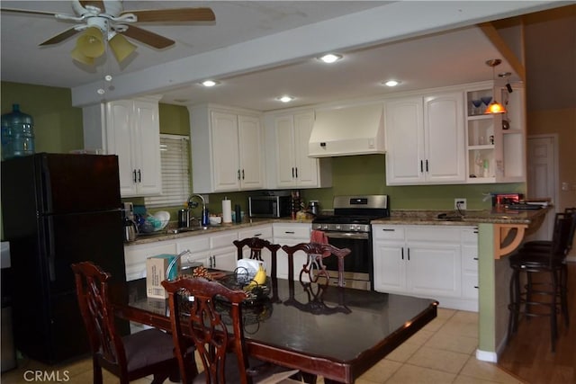 kitchen featuring ceiling fan, custom exhaust hood, white cabinets, stainless steel appliances, and a sink