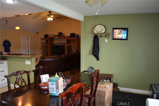 dining area with vaulted ceiling with beams, a ceiling fan, and baseboards